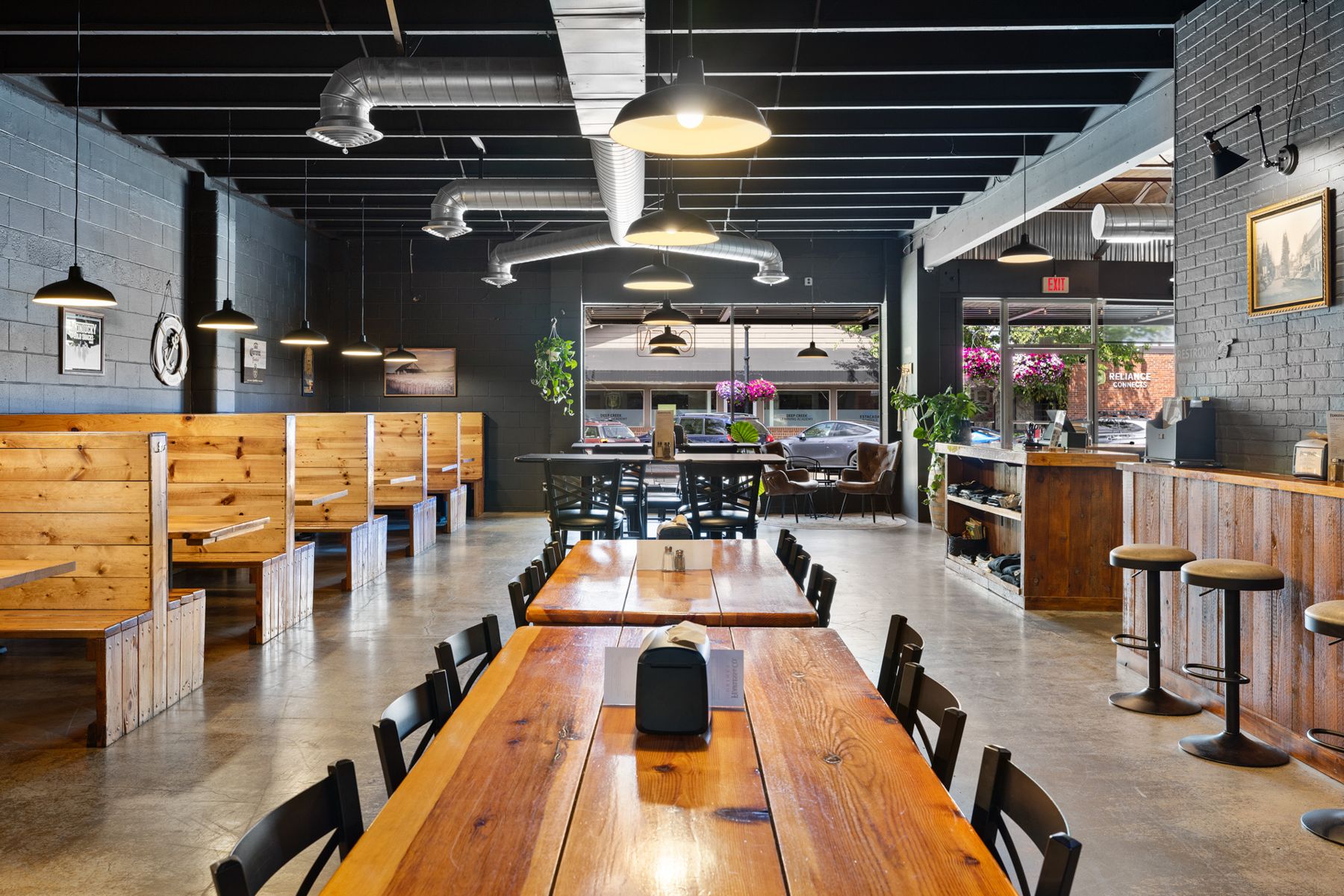 Dining room with natural wood booths, long timber tables and pendant lights