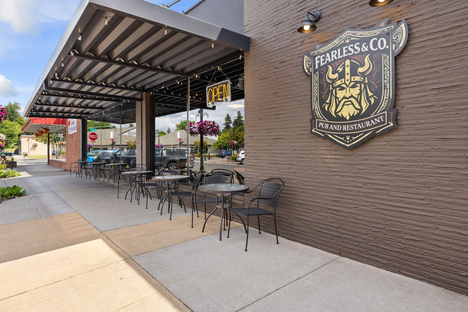 Covered sidewalk patio outside Fearless & Co. with the Viking crest on the brick wall